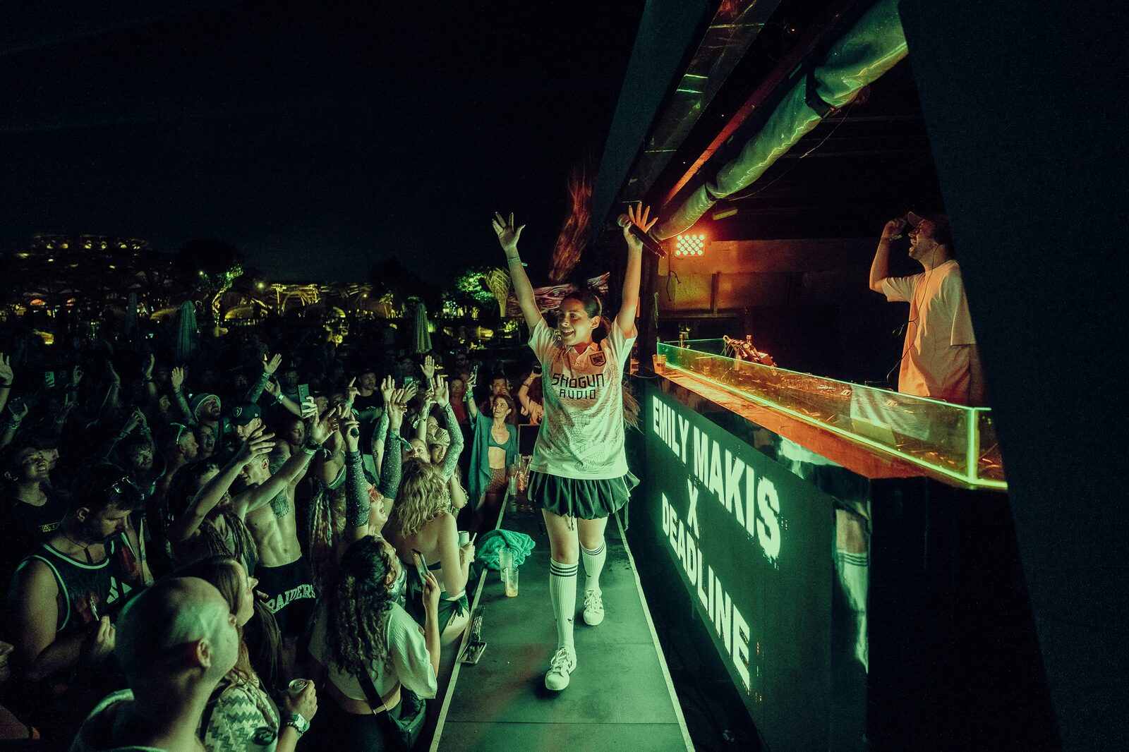 MC walking onstage to a green-lit crowd at LOCUS Bali 2025